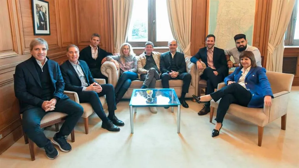 Dirigentes políticos sentados en sillones dentro de un despacho oficial.